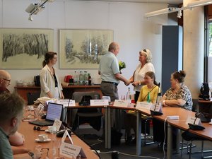 Saal mit sitzenden Teilnehmenden, Bildmitte: TLMB Leibiger dankt Gerda redehorn für ihre Arbeit. Klick öffnet eine vergrößerte Ansicht.