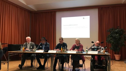 Joachim Leibiger bei seinem Vortrag am 02.02. in Dresden; weitere Teilnehmer im Podium: Ingo Berger Stellvertretende Vors. Landesbehindertenbeirat Sachsen, Ralph Beckert Vors. Landesbehindertenbeirat, Pia Lehmann Mitglied LBB sowie Jens Merkel Mitglied LBB 