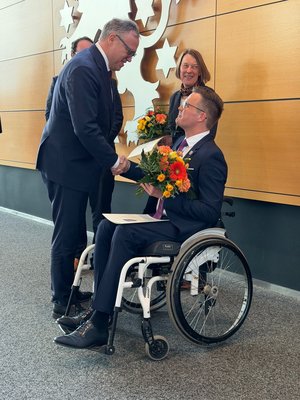 MP Voigt gratuliert Herrn Petschner zur Wahl, im Hintergrund die Bürgerbeauftragte Democh. Klick öffnet eine vergrößerte Ansicht.