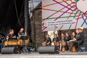 Trommelgruppe die "Kongas" auf der Bühne sitzend . Klick öffnet eine vergrößerte Ansicht.