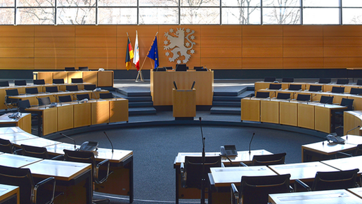 Blick in den Plenarsaal mit Rednerpult und Sitzreihen
