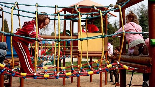 Kinder klettern auf dem Spielplatz