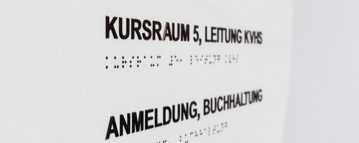 Tafel des Leitsystems mit Braillezeile, Treppenhaus der VHS