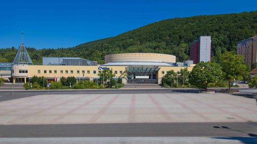 Außenansicht des Konferenzzentrum CCS in Suhl. Gelbes Gebäude mit Kuppel an Straßenübergang.
