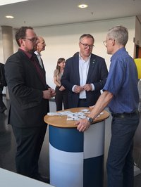 Landtagspräsident Dr. König mit MP Voigt am Stand des TLMB, im Gespräch mit Markus Lorenz. Klick öffnet eine vergrößerte Ansicht.