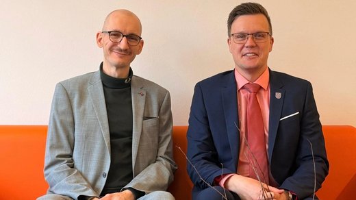 Alexander Brick, LIGA Selbstvertretung neben Dennis Petschner sitzend auf der orang en Couch im Büro des TLMB