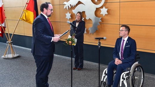 Landtagspräsident Dr. König vereidigt Dennis Petschner als neuen TLMB, D. Petschner im Rollstuhl sitzend, im Bildhintergrund die neugewählte Bürgerbeauftragte Democh