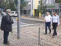 Teilnehmende am Selbsterfahrungsworkshop beim Überquerren der Straße mit Brille und Langstock